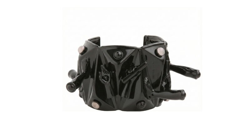 Black varnished sculptural COMPRESSION cuff bracelet by Milius with geometric reliefs, embedded stones, and protruding hand-formed elements.