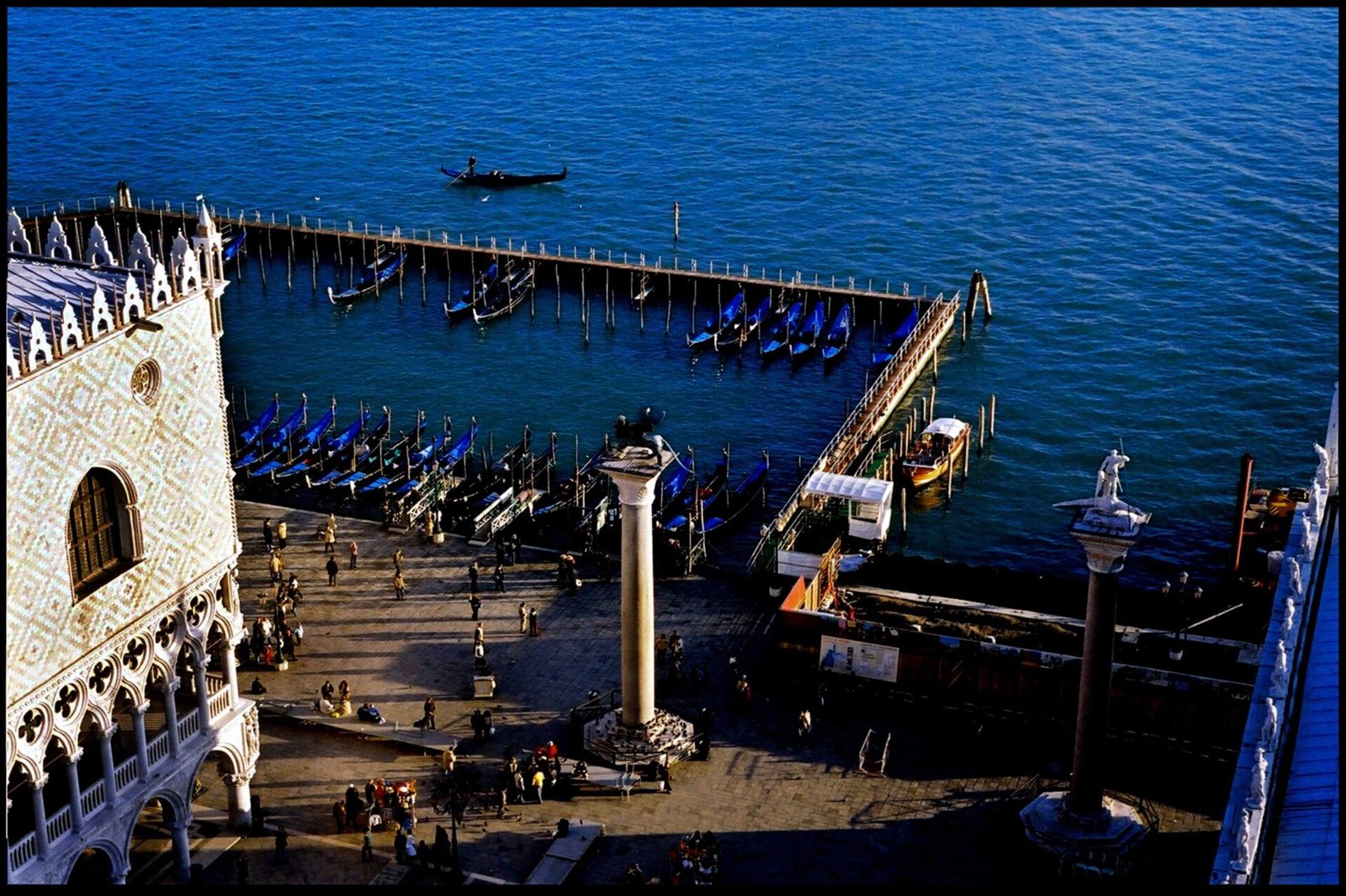 Venetian waterfront and gondola pier overlooking open sea photographed on analog film by Milan Stamenovic, exploring architecture, human presence, and the threshold between city and water in Landscapes of the Remembering World.