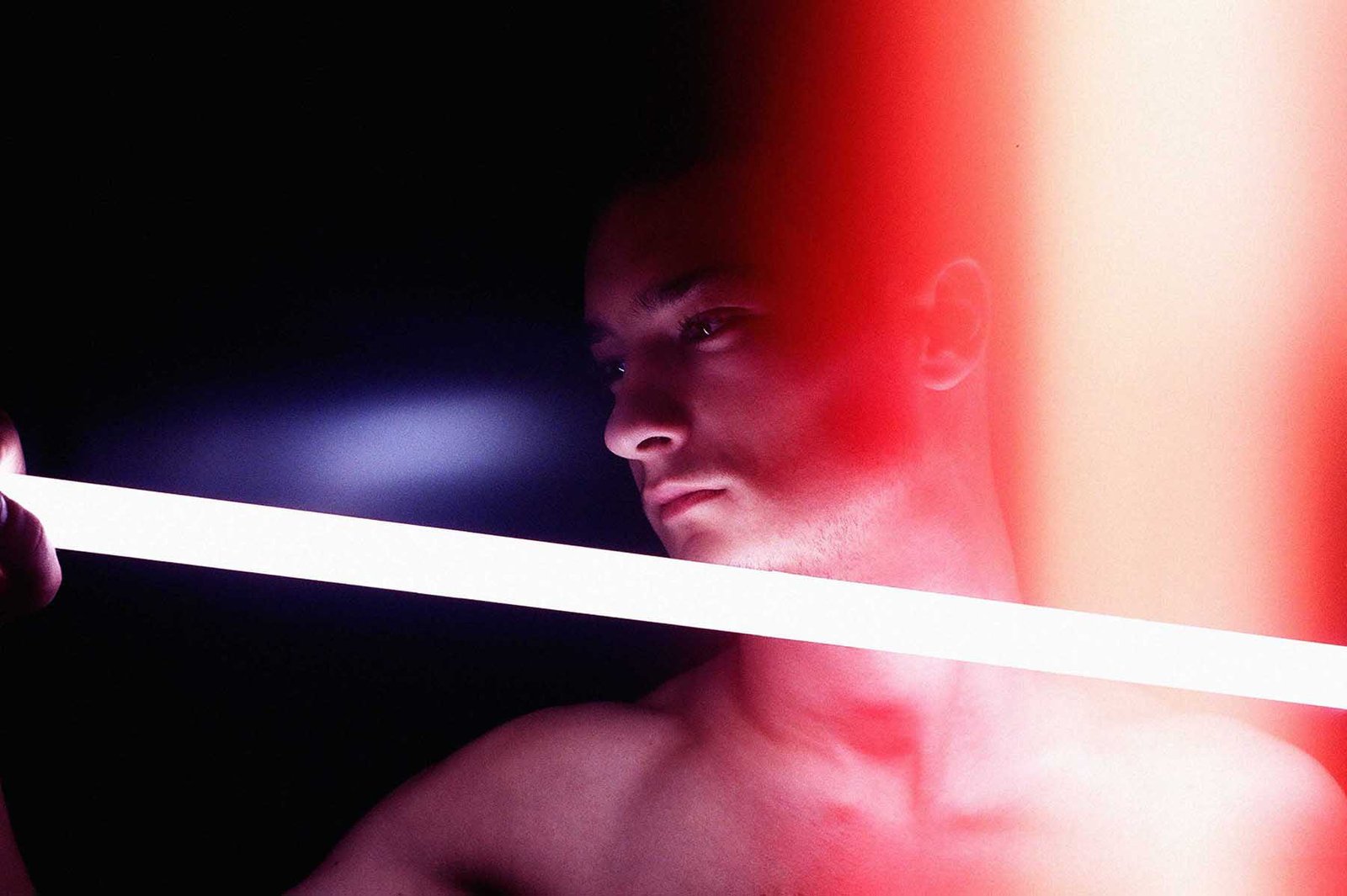 Contemporary portrait photograph exploring illumination as a volatile force, where light behaves like flame, carrying memory, heat, and consequence across the human face and body.