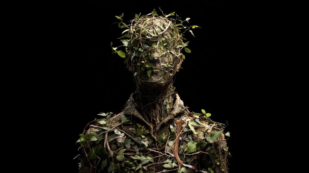 Wearable art jewelry from the Hunter Collection shown on a humanoid totem at a threshold moment.