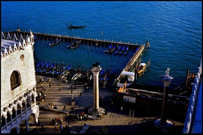 Venetian waterfront and gondola pier overlooking open sea photographed on analog film by Milan Stamenovic, exploring architecture, human presence, and the threshold between city and water in Landscapes of the Remembering World.