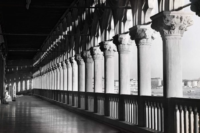 Colonnade with repeating stone pillars and shadow patterns photographed on analog film by Milan Stamenovic, exploring memory, architectural thought, and post-human space in Landscapes of the Remembering World.