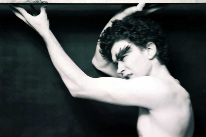 Black-and-white fine art analog portrait of a human figure pushing upward against a surface, expressing resistance, tension, and bodily endurance in a myth-oriented photographic work by Milan Stamenovic.