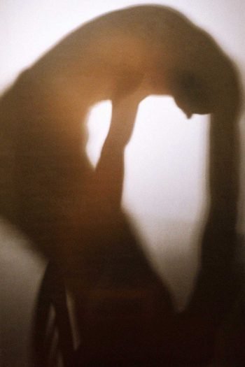Blurred silhouette of a human body bending inward, exploring self-formation, desire, and internal pressure in Milan Stamenovic’s The Hidden Surface photographic series.